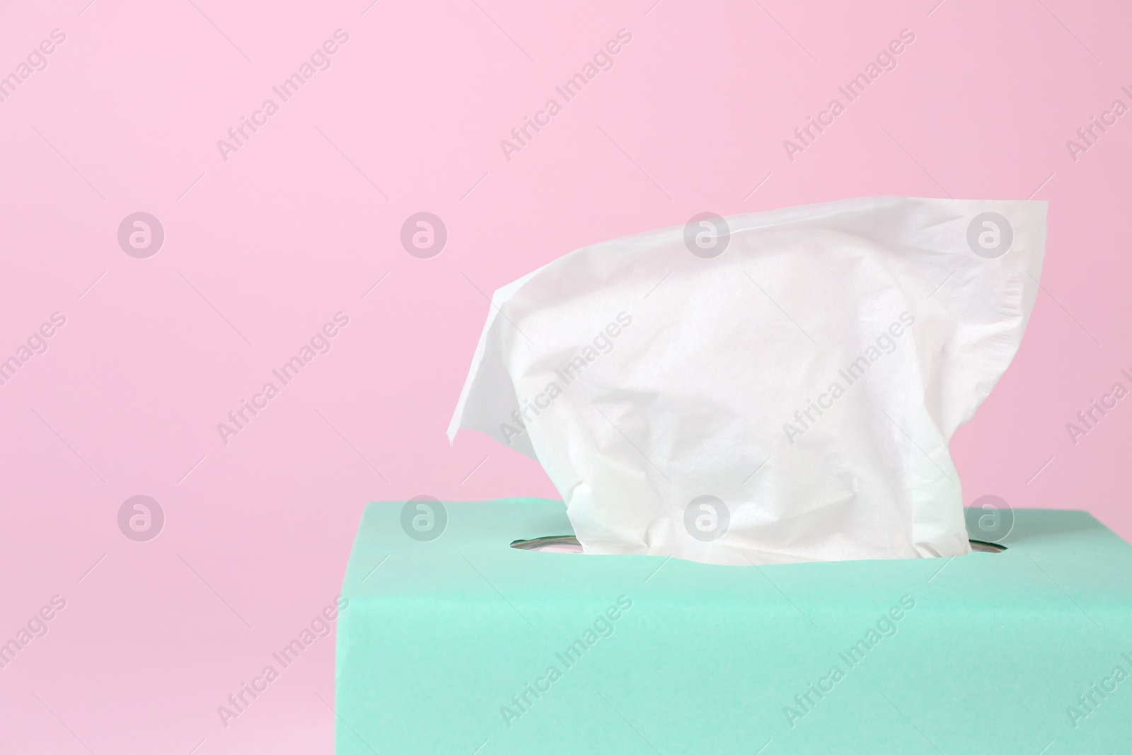 Photo of Box with paper tissues on pink background, closeup