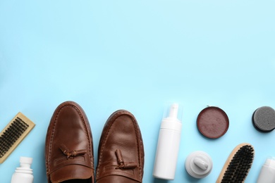 Flat lay composition with shoe care accessories and footwear on light blue background. Space for text