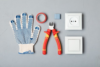Flat lay composition with electrician's tools on gray background