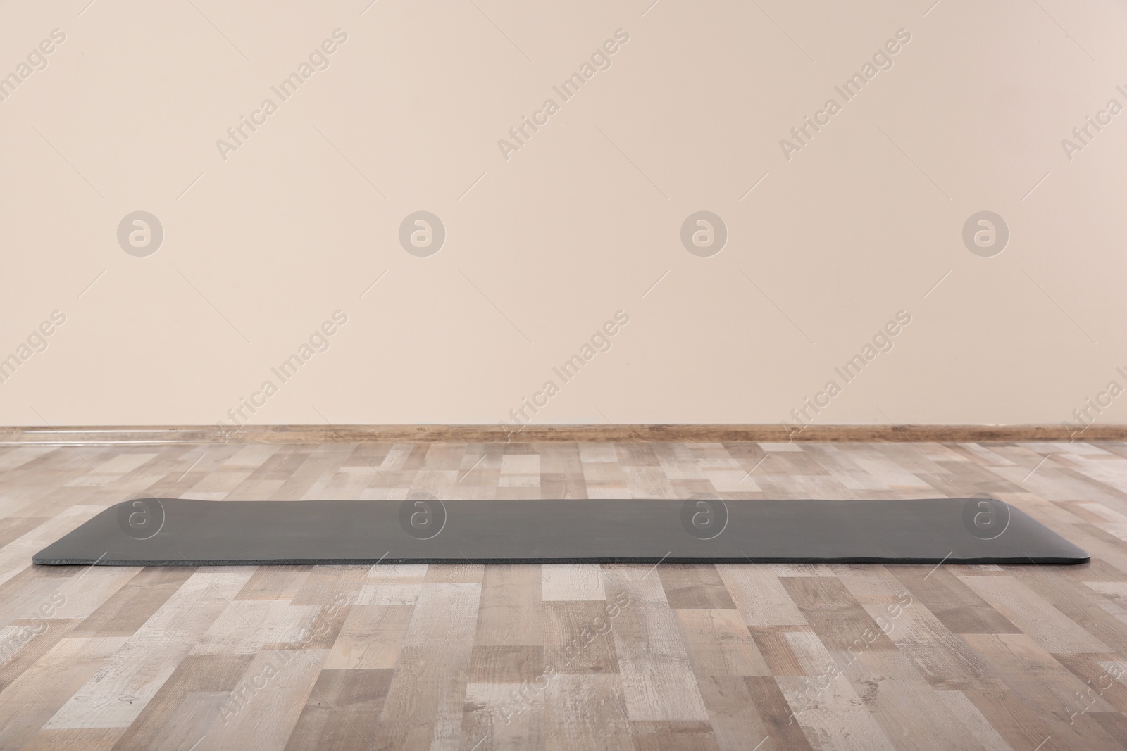 Photo of Grey yoga mat on floor indoors. Space for text