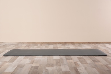 Grey yoga mat on floor indoors. Space for text