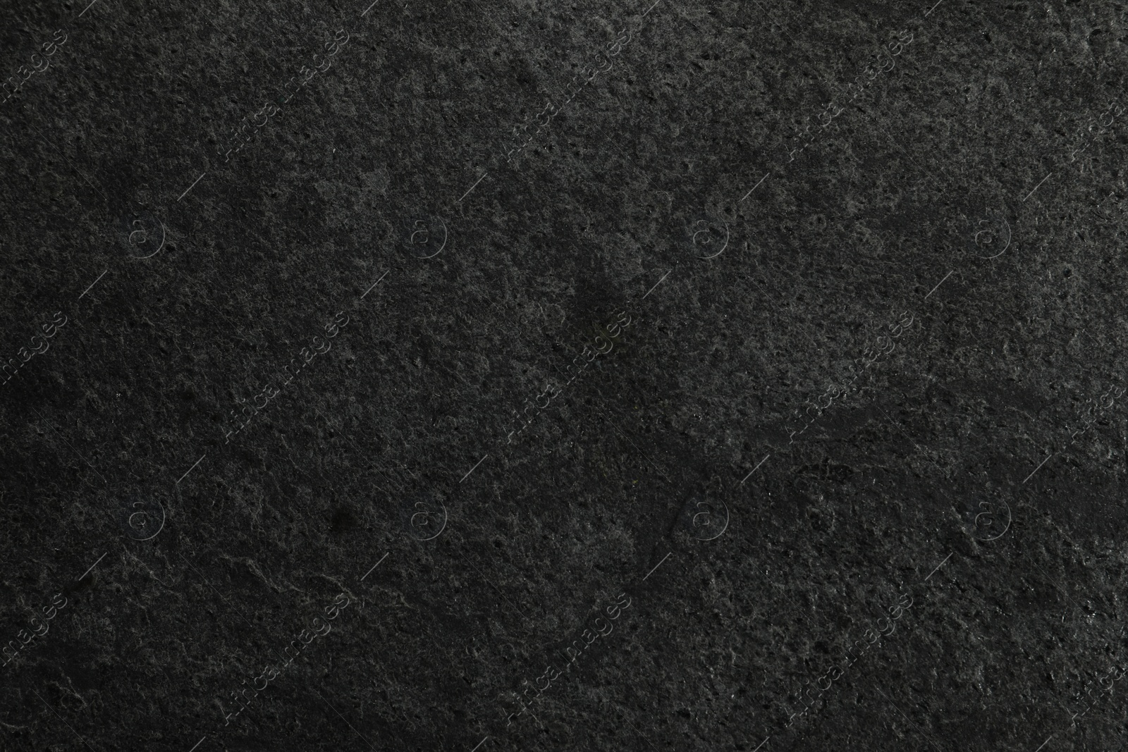 Photo of Texture of dark grey stone surface as background, closeup