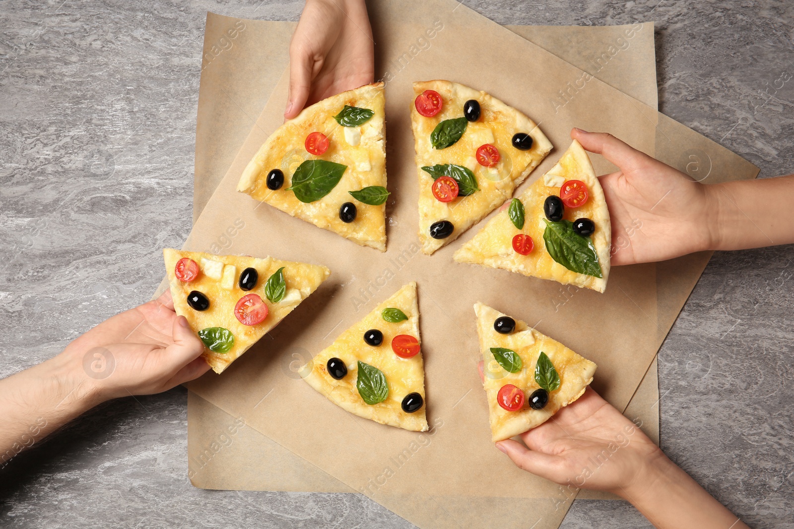 Photo of People taking tasty homemade pizza slices from table, top view