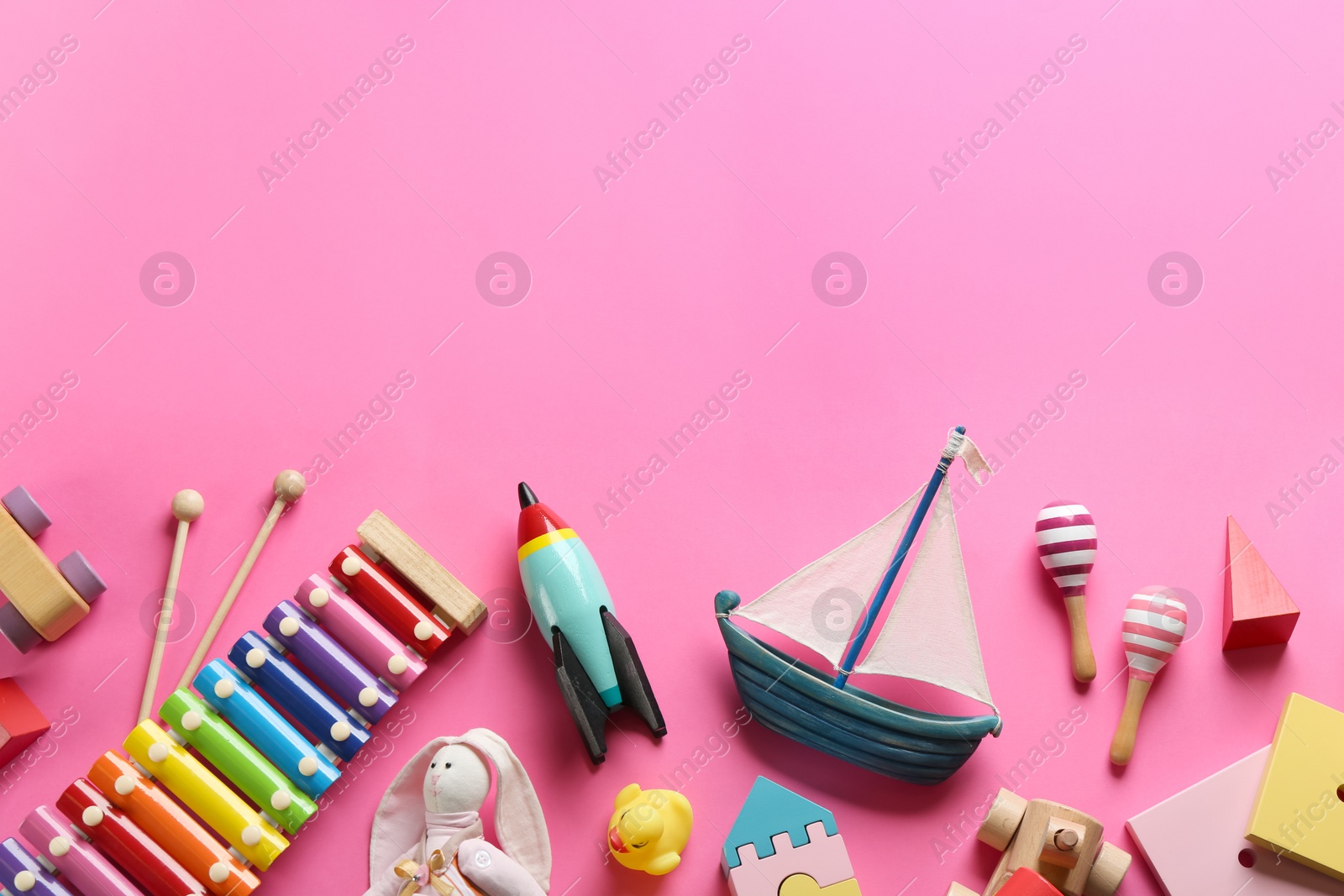 Photo of Flat lay composition with different toys on pink background. Space for text