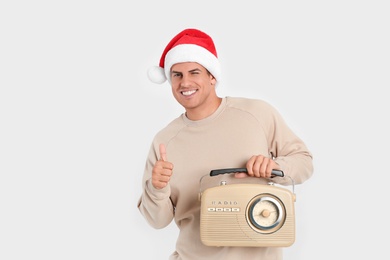 Photo of Happy man with vintage radio on white background. Christmas music