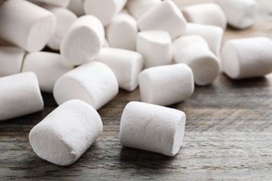 Delicious puffy marshmallows on wooden table, closeup