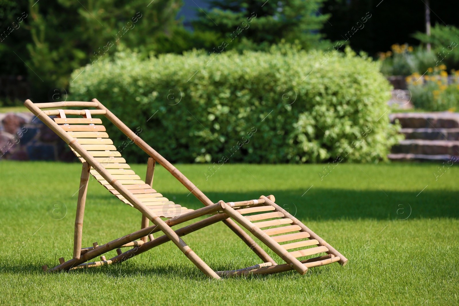 Photo of Wooden deck chair in beautiful garden on sunny day