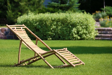 Wooden deck chair in beautiful garden on sunny day