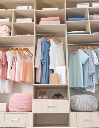 Photo of Stylish clothes, shoes and accessories in large wardrobe closet, below view