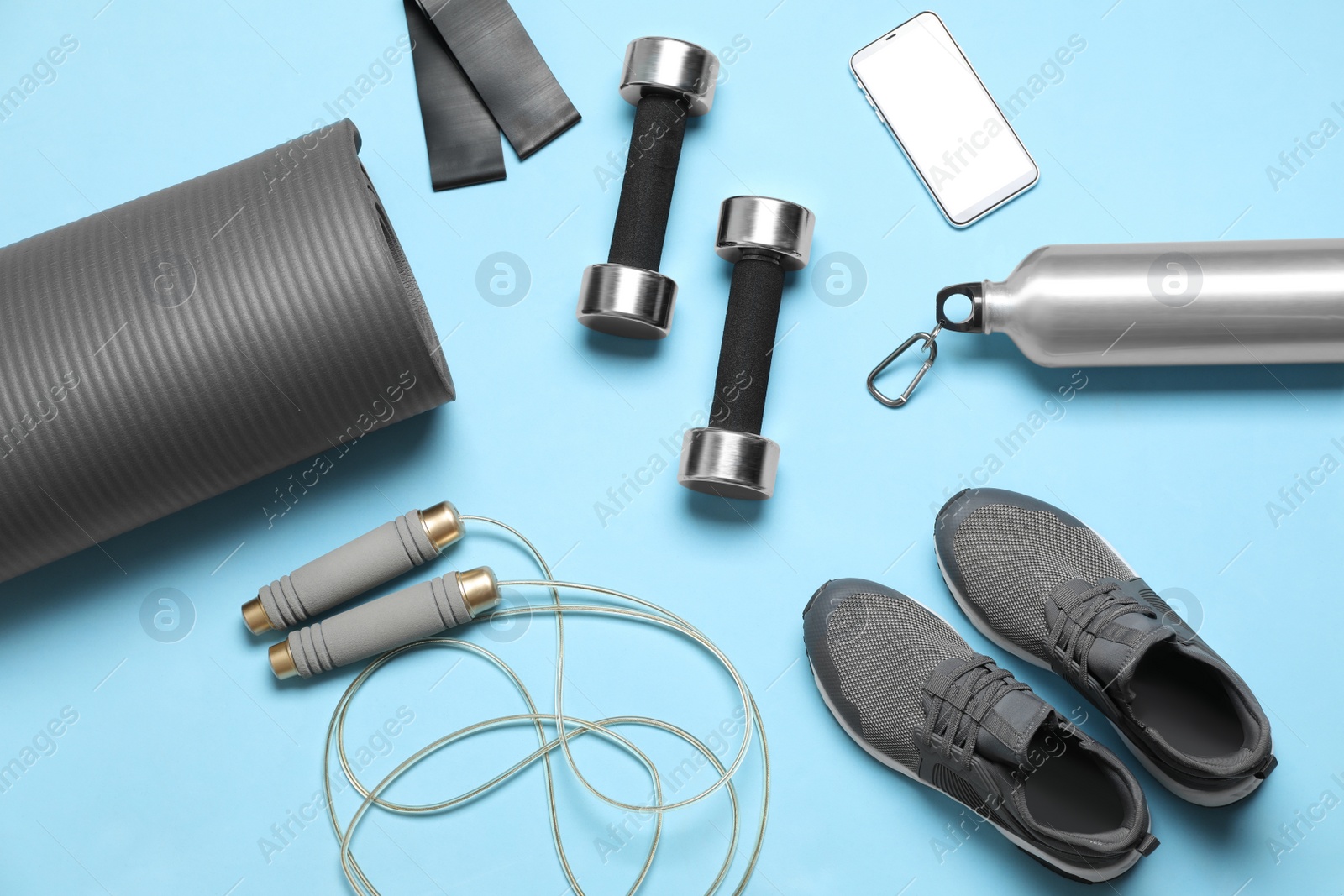 Photo of Flat lay composition with sports equipment on light blue background