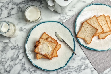 Photo of Plates with toasted bread and fresh milk on table, top view