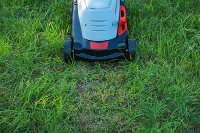 Photo of Lawn mower on green grass in garden