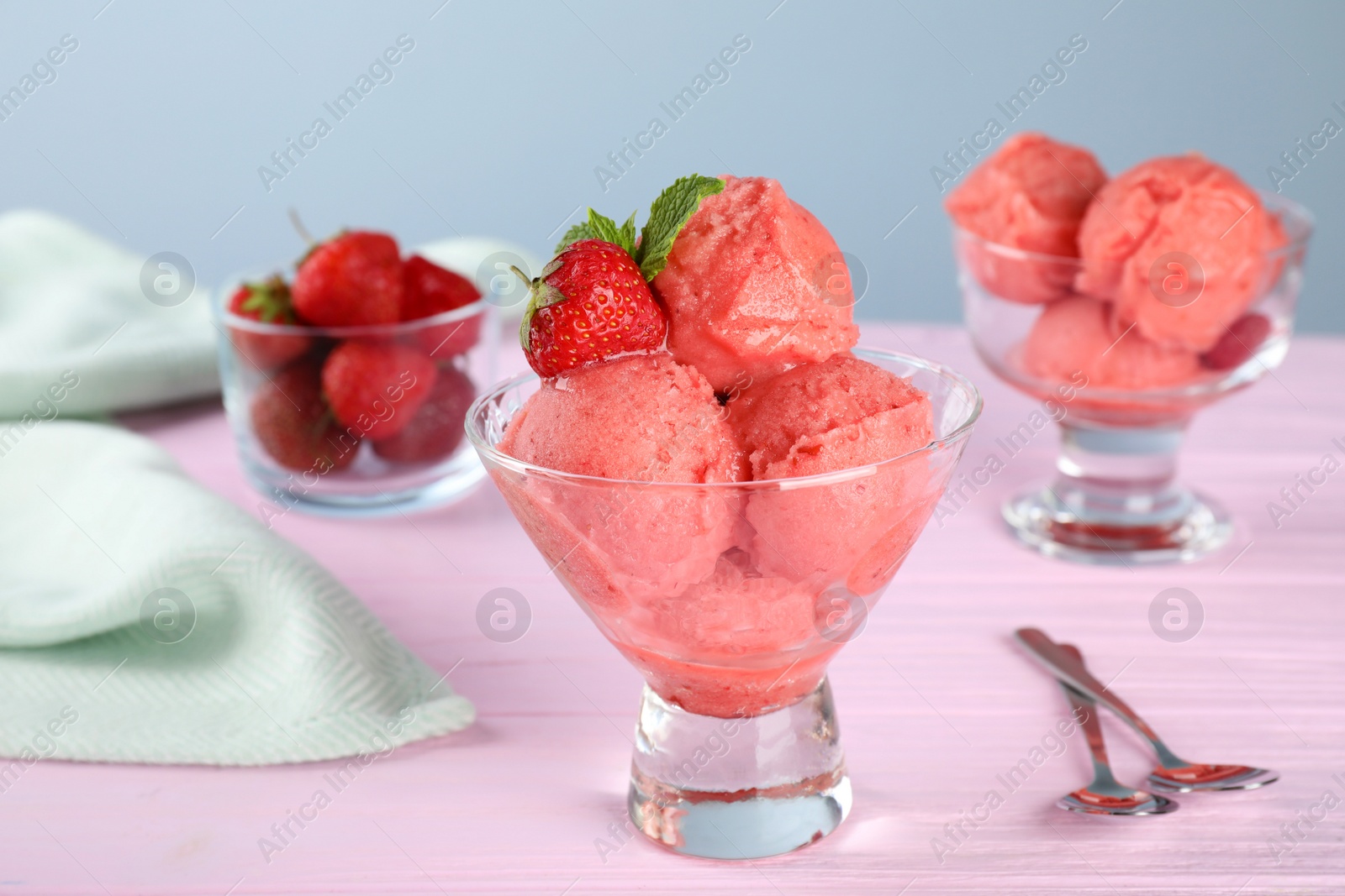 Photo of Delicious strawberry ice cream in dessert bowl served on pink wooden table