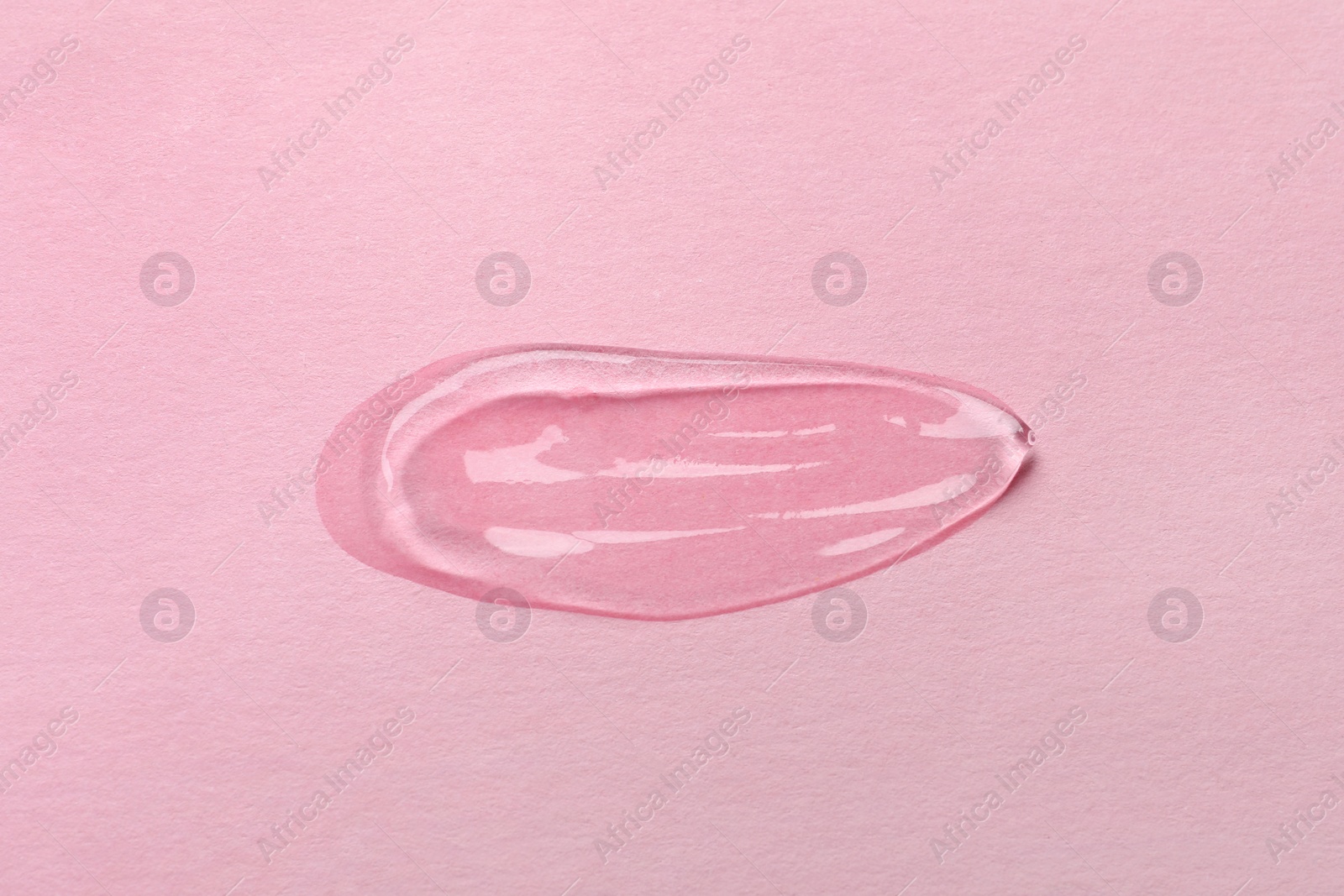 Photo of Sample of transparent gel on pink background, top view