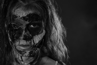 Photo of Scary zombie on dark background, black and white effect. Halloween monster