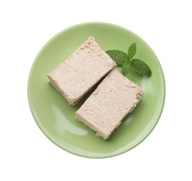 Plate with pieces of tasty halva and mint isolated on white, top view