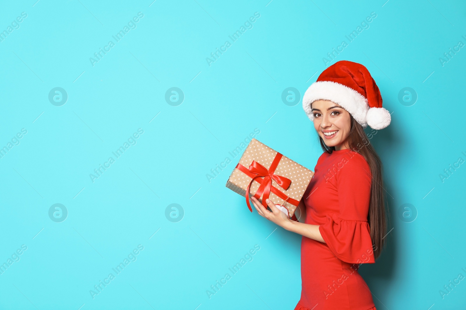 Photo of Young woman with Christmas gift on color background