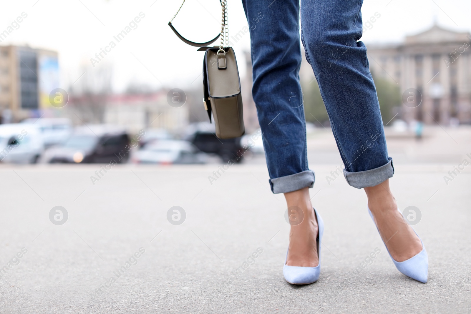 Photo of Young woman in elegant shoes walking on street