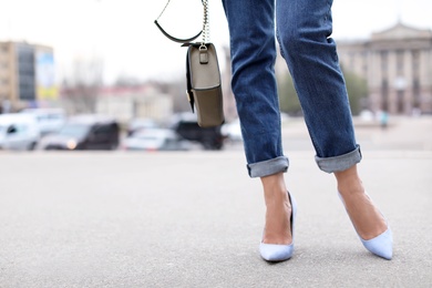 Photo of Young woman in elegant shoes walking on street