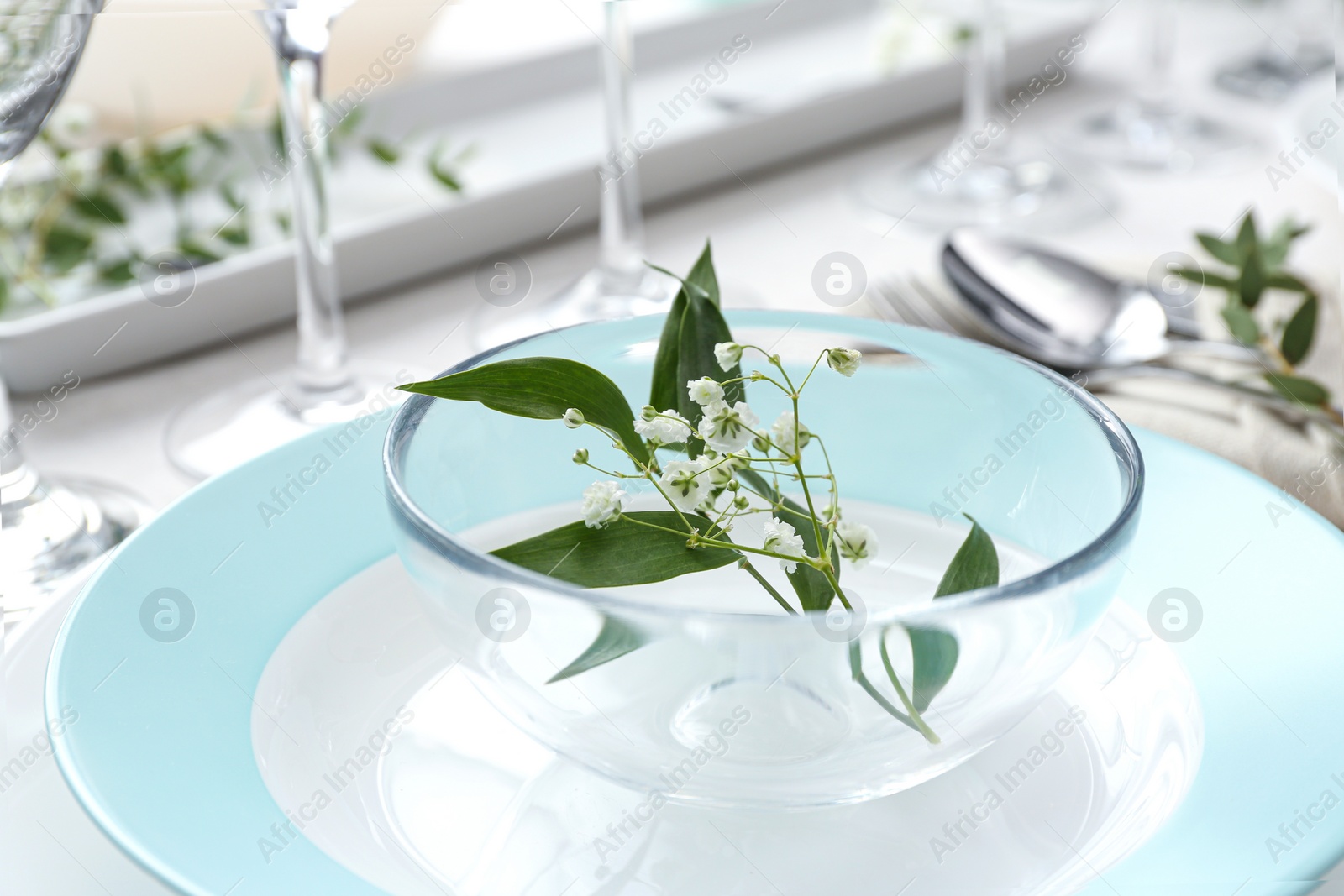 Photo of Stylish tableware with leaves and flowers on table, closeup. Festive setting