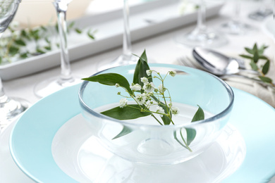 Photo of Stylish tableware with leaves and flowers on table, closeup. Festive setting
