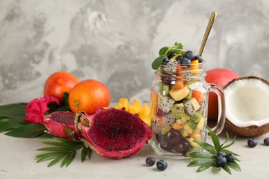Photo of Composition with delicious salad of exotic fruits on light grey table