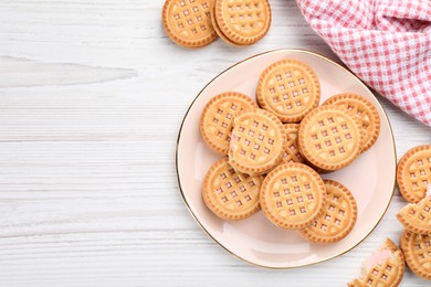 Photo of Tasty sandwich cookies with cream on white wooden table, flat lay. Space for text