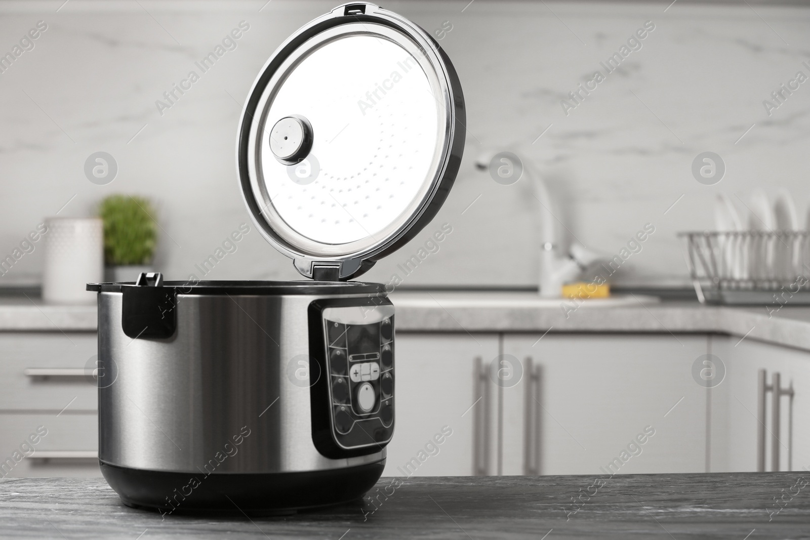 Photo of Modern multi cooker on table in kitchen. Space for text