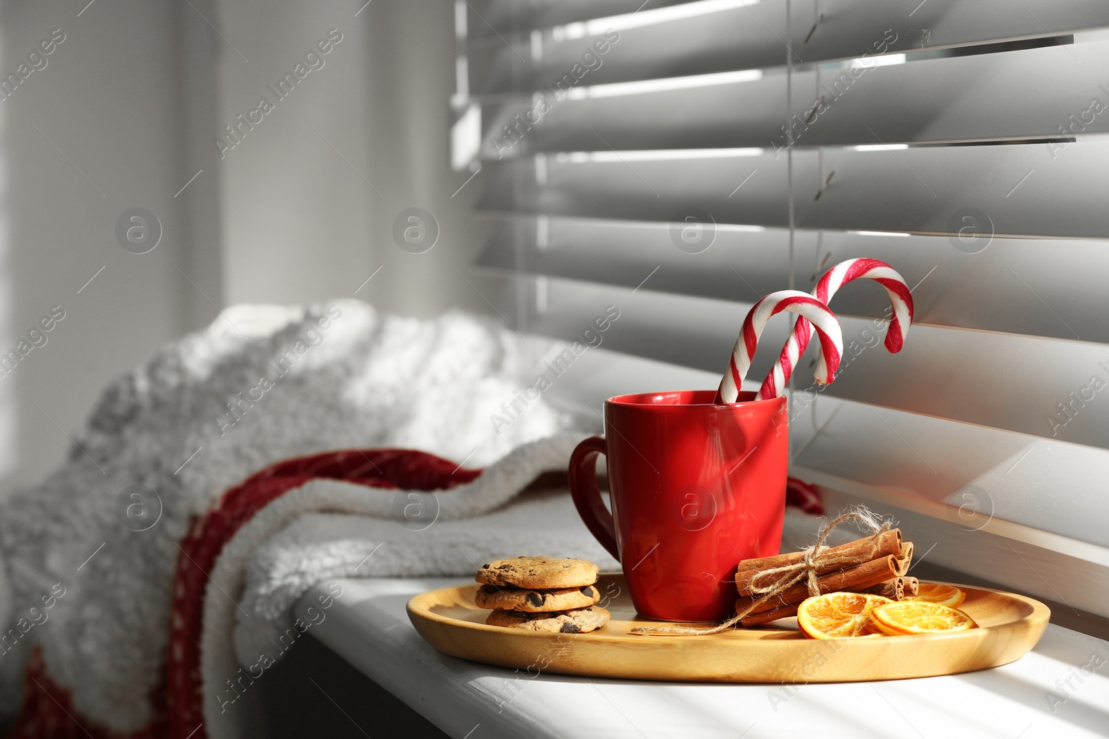 Photo of Cup of hot winter drink and treats on windowsill indoors. Space for text