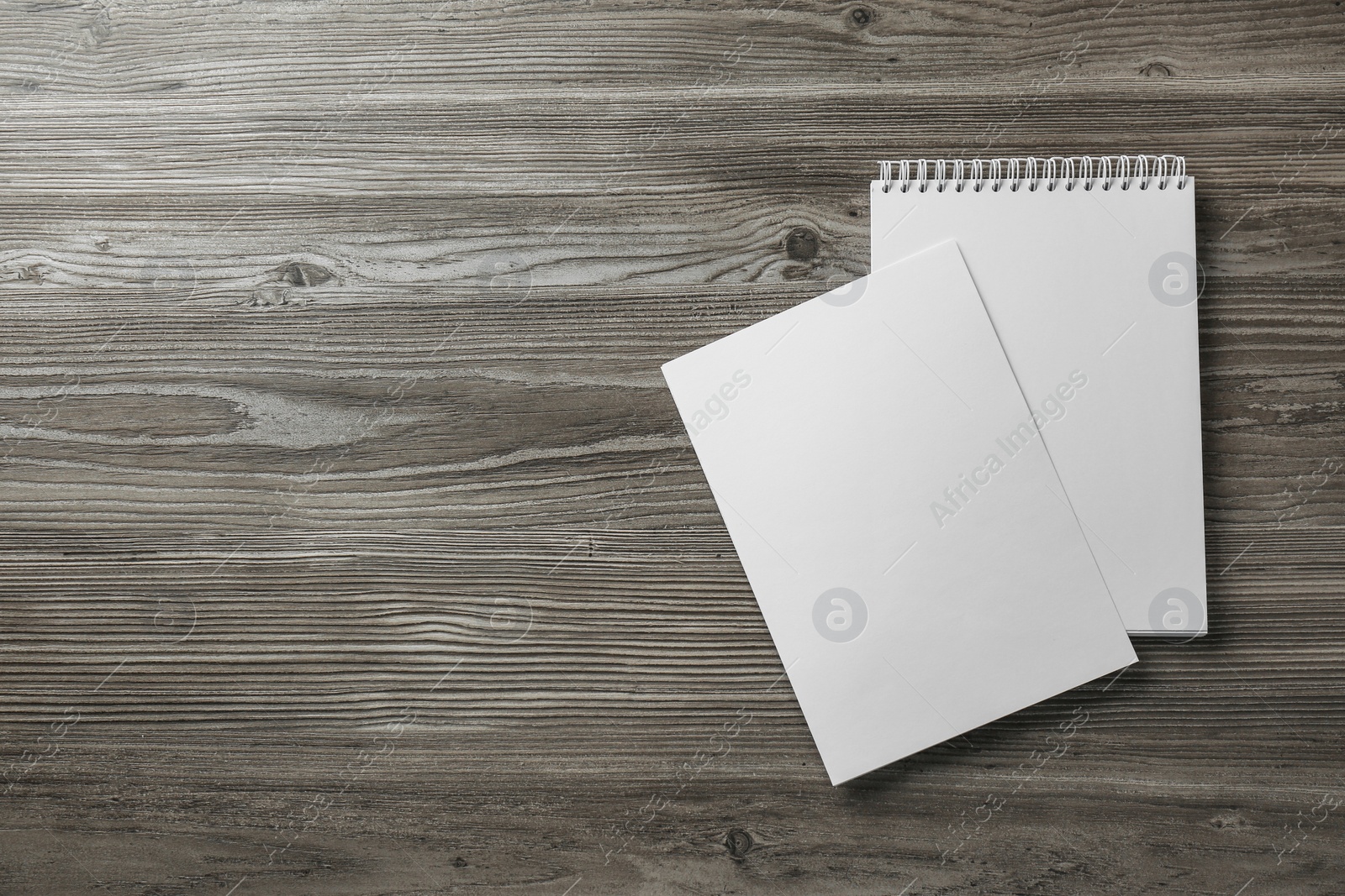 Photo of Sheet of paper and blank brochure on wooden table, flat lay. Mockup for design