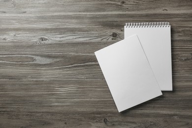 Sheet of paper and blank brochure on wooden table, flat lay. Mockup for design