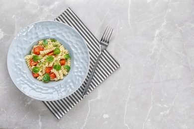 Photo of Tasty pasta salad with tomatoes on table