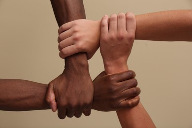 Photo of Men joining hands together on beige background, closeup