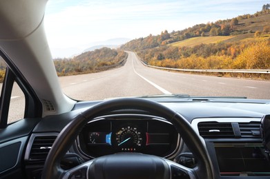 Image of Dashboard with speedometer behind steering wheel inside car