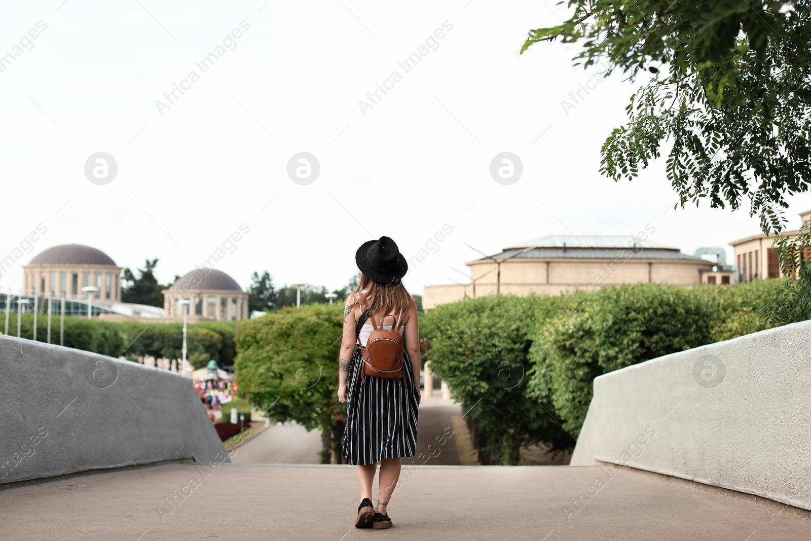 Photo of Young woman in stylish outfit on city street