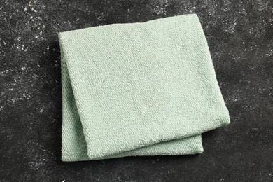 Photo of Soft terry towel on black textured background, top view