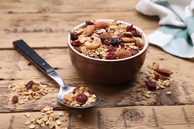 Photo of Tasty granola served with nuts and dry fruits on wooden table