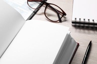 Photo of Law. Book, glasses, form and stationery on wooden table, closeup