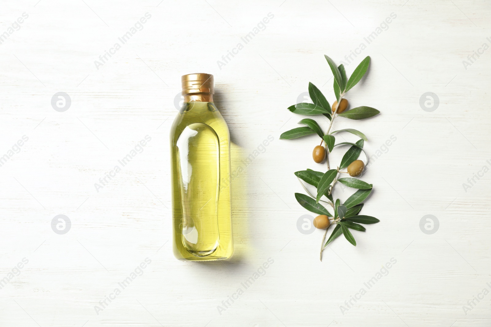 Photo of Flat lay composition with bottle of oil and olive tree twig on white wooden background