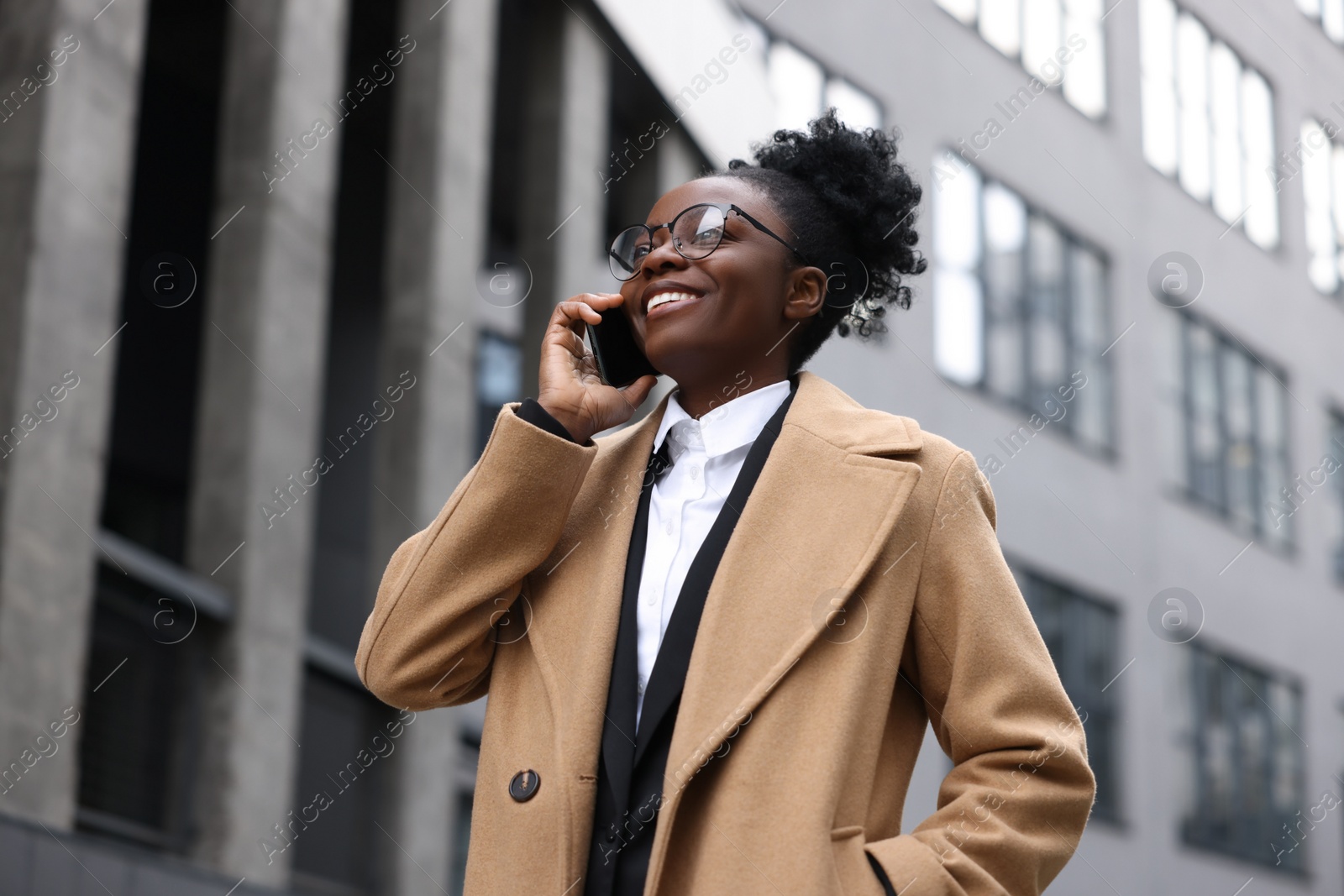 Photo of Happy woman talking on smartphone outdoors. Lawyer, businesswoman, accountant or manager