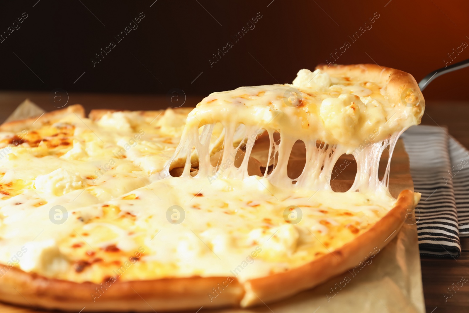 Photo of Shovel with slice of delicious hot pizza over table, closeup