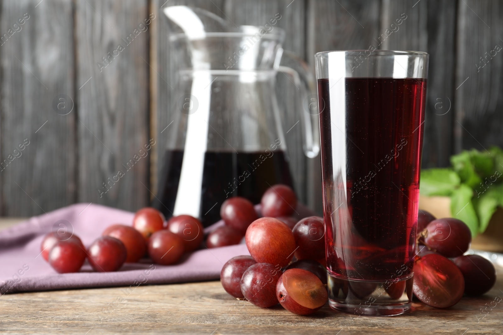 Photo of Delicious grape soda water with berries on wooden table. Refreshing drink