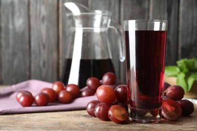 Photo of Delicious grape soda water with berries on wooden table. Refreshing drink