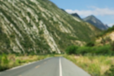 Blurred view of mountains and empty asphalt highway outdoors. Road trip