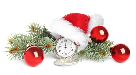 Photo of Pocket watch with Santa hat and festive decor on white background. New Year countdown