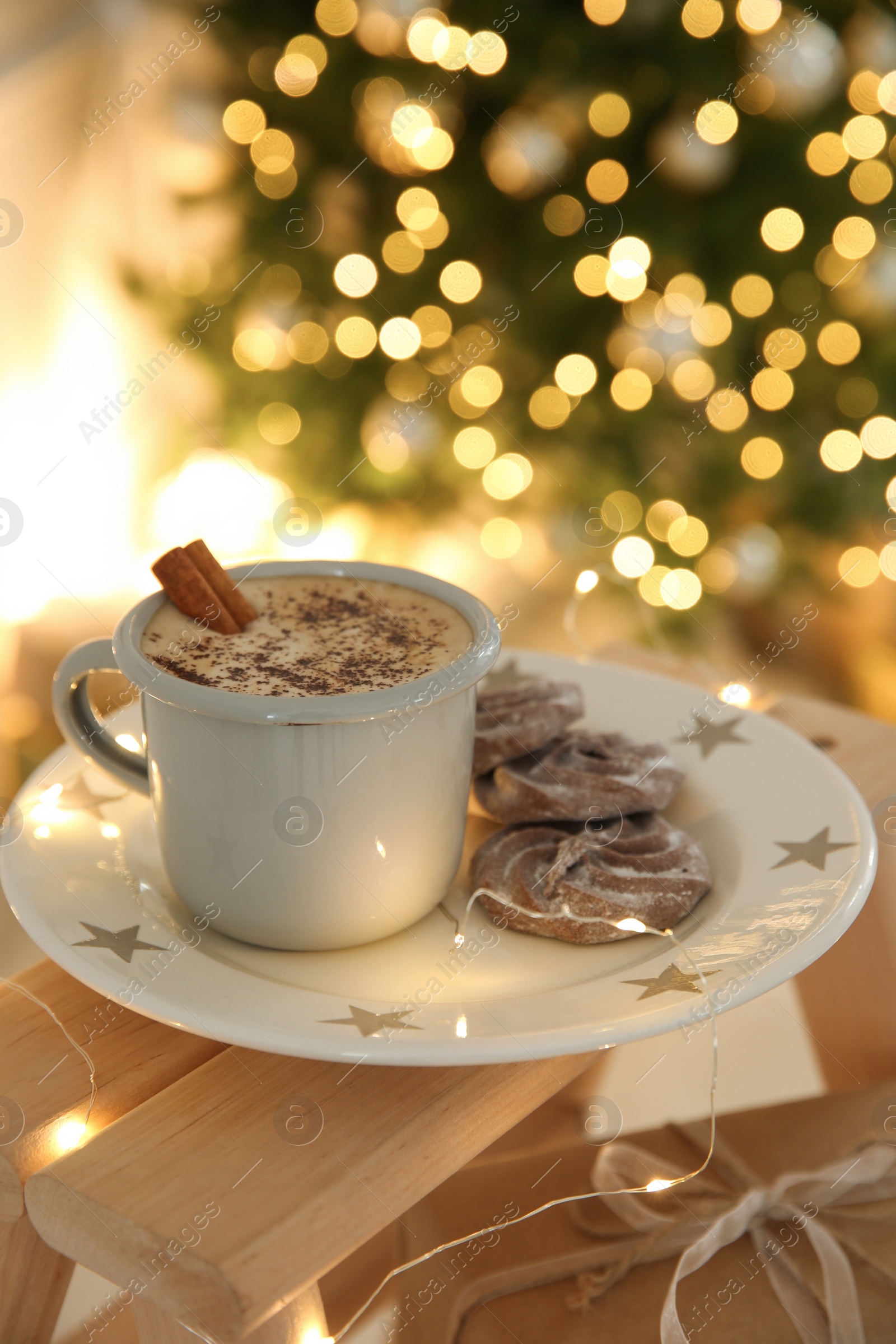 Photo of Tasty hot drink, cookies and Christmas lights in room