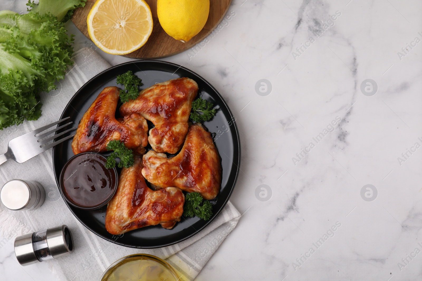 Photo of Flat lay composition with marinade and chicken wings on white marble table. Space for text