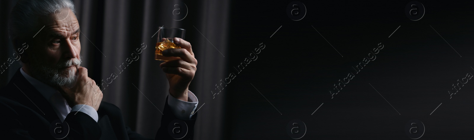 Image of Man with glass of whiskey on dark background, space for text. Banner design