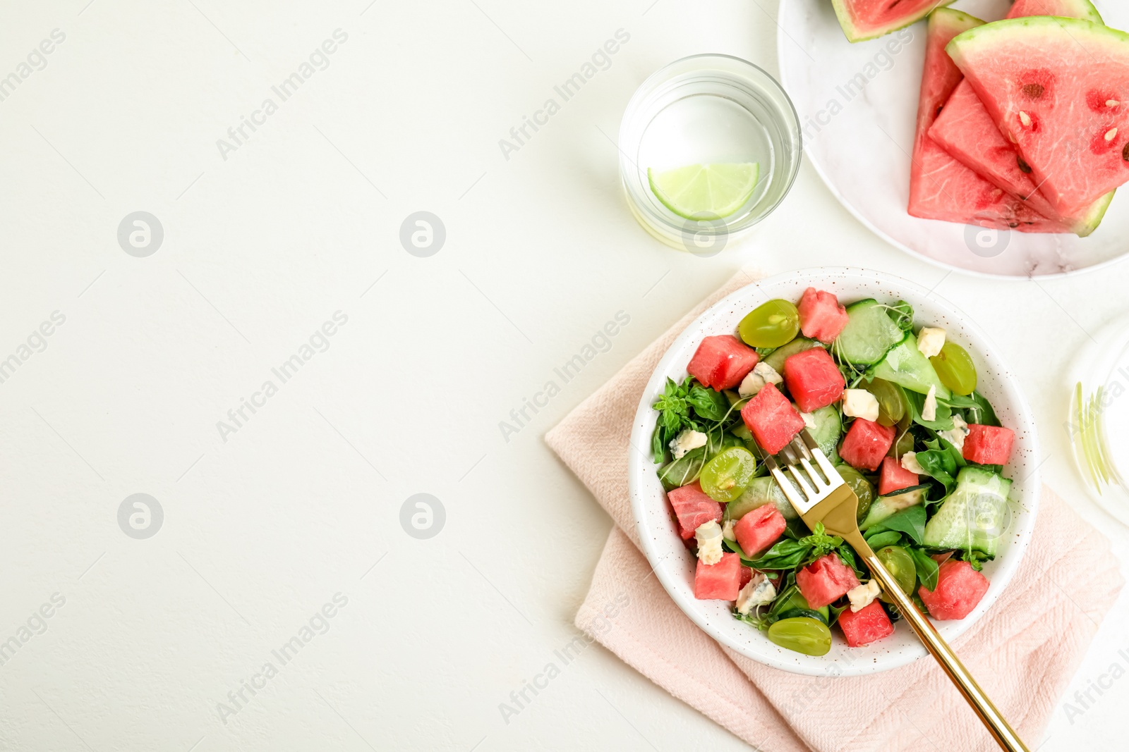 Photo of Delicious salad with watermelon served on white table, flat lay. Space for text