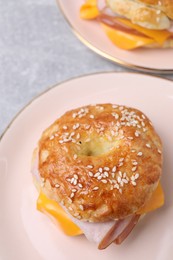 Photo of Delicious bagel with ham and cheese on table